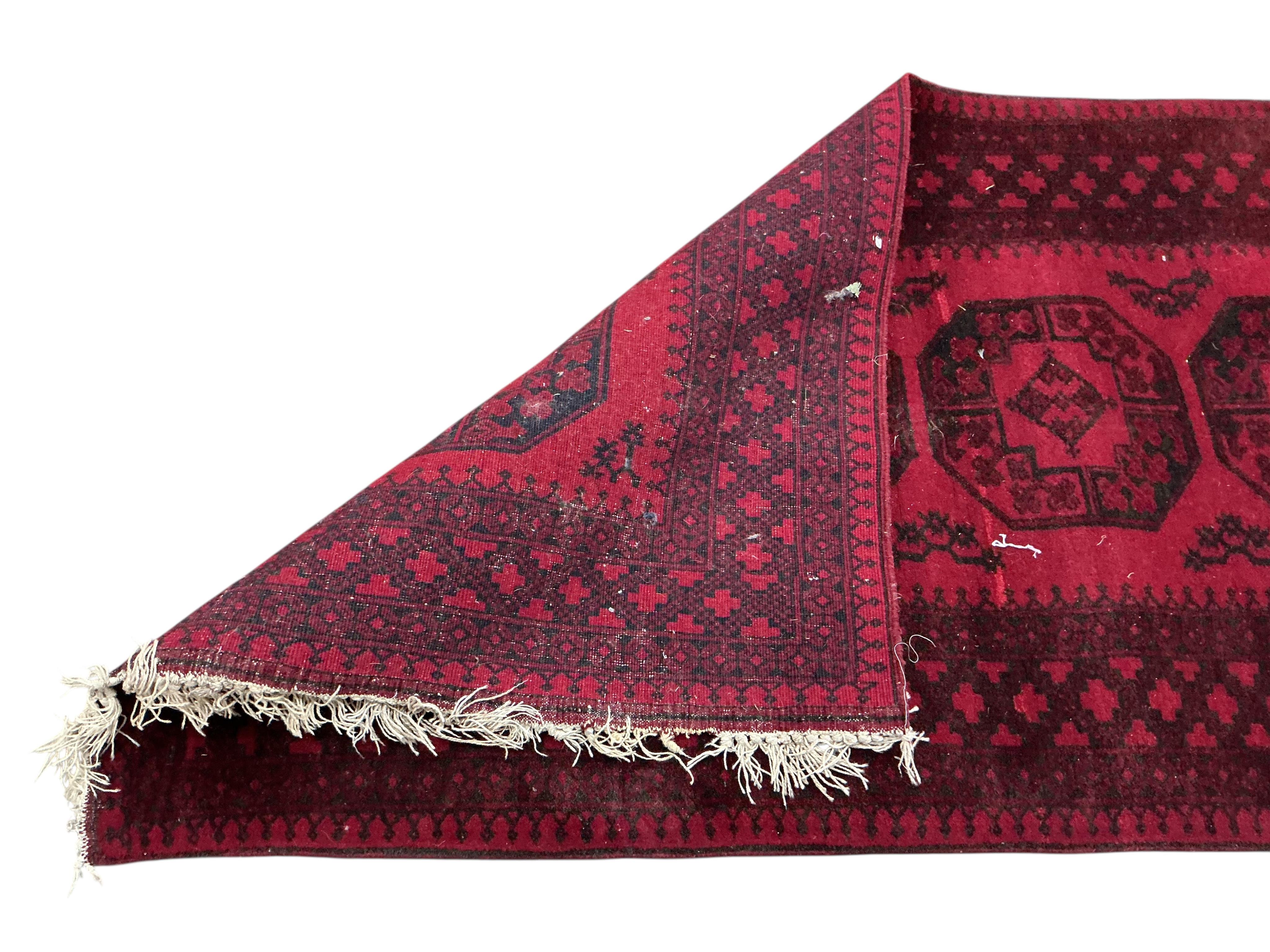 An Afgahn red ground wool rug, 200 x 108cm